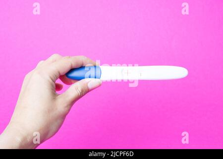 Test di gravidanza positivo nel primo piano del braccio Foto Stock