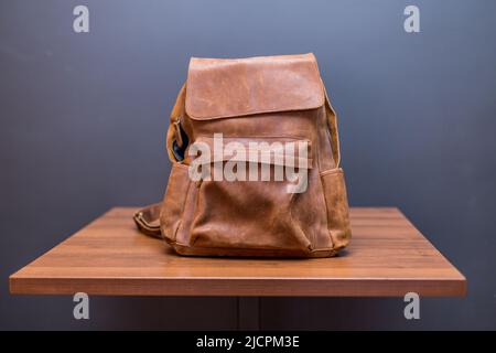 Zaini in pelle marrone su tavola in legno. Borsa UNISEX Foto Stock