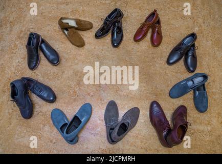 Molti paia di scarpe sullo sfondo beige Foto Stock
