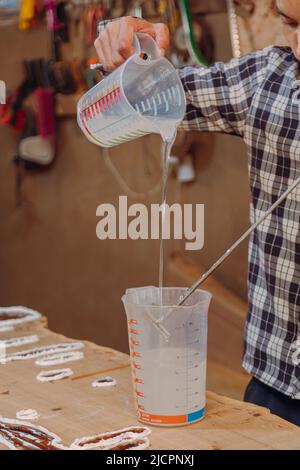Carpentiere preparazione resina epossidica. Processo di fabbricazione di una resina artigianale e tavola di legno Foto Stock
