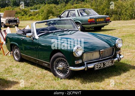 Vista frontale di tre quarti di un verde scuro, 1970 MG Midget Mk III, in mostra al Deal Classic Car Show 2022 Foto Stock