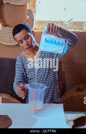 Carpentiere per la preparazione di resina epossidica per la lavorazione del legno e la carpenteria Foto Stock