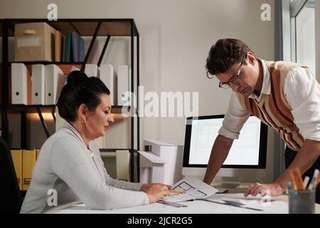 Architetti che calcolano il costo di costruzione di un muro aggiuntivo sul primo piano della casa dei clienti Foto Stock