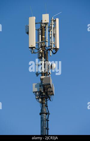 primo piano di un supporto antenna per comunicazioni radio mobili di fronte al cielo blu Foto Stock