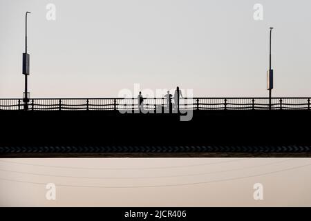 Persone in piedi e che guardano sul corrimano di un ponte sul Nilo, Egitto Foto Stock