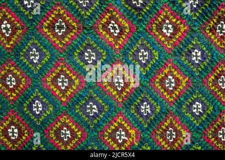 Tappeto multicolore fatto a mano con ornamento in rombo, tappeto intrecciato, primo piano, fondo texture. Foto Stock