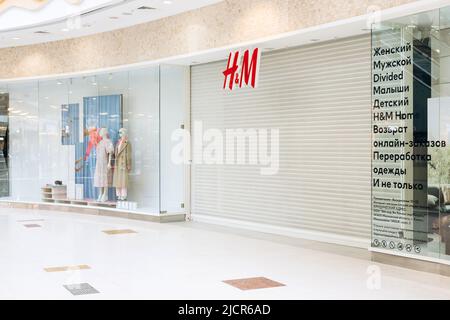 San Pietroburgo, Russia - 04.01.2022: Hennes e Mauritz o hm o H e M è chiuso nel centro commerciale di San Pietroburgo. Sportello dell'otturatore a rullo bianco o. Foto Stock