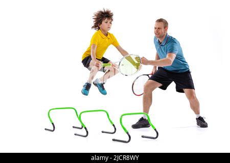 Lezione di tennis. Professionista giocatore di tennis, istruttore mostra tecniche di base nel gioco del tennis a ragazzo di età scolastica. Concetto di sport, realizzazioni Foto Stock