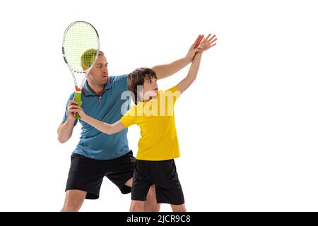 Lezione di tennis. Professionista giocatore di tennis, istruttore mostra tecniche di base nel gioco del tennis a ragazzo di età scolastica. Concetto di sport, realizzazioni Foto Stock