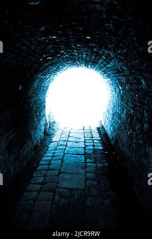 tunnel scuro con luce alla fine Foto Stock