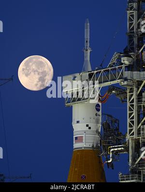 Una luna piena è dietro il razzo Space Launch System (SLS) della NASA, che si trova sul complesso 39B in preparazione ai test al Kennedy Space Center, Florida, mercoledì 15 giugno 2022. La NASA celebra anche il 60th° anniversario del Kennedy Space Center. Foto di Joe Marino/UPI Credit: UPI/Alamy Live News Foto Stock