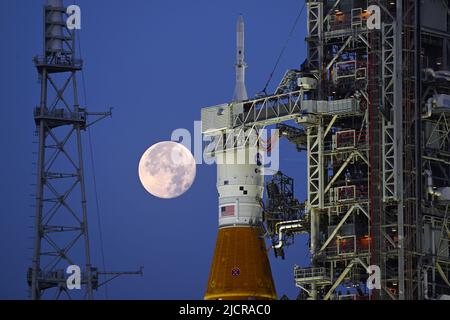 Una luna piena è dietro il razzo Space Launch System (SLS) della NASA, che si trova sul complesso 39B in preparazione ai test al Kennedy Space Center, Florida, mercoledì 15 giugno 2022. La NASA celebra anche il 60th° anniversario del Kennedy Space Center. Foto di Joe Marino/UPI Credit: UPI/Alamy Live News Foto Stock