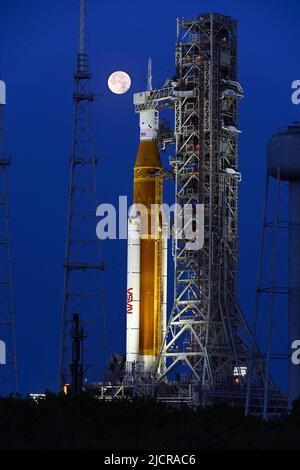 Una luna piena è dietro il razzo Space Launch System (SLS) della NASA, che si trova sul complesso 39B in preparazione ai test al Kennedy Space Center, Florida, mercoledì 15 giugno 2022. La NASA celebra anche il 60th° anniversario del Kennedy Space Center. Foto di Joe Marino/UPI Credit: UPI/Alamy Live News Foto Stock