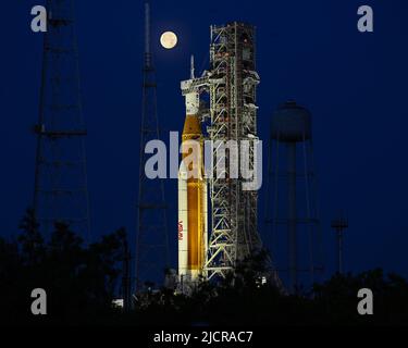 Una luna piena è dietro il razzo Space Launch System (SLS) della NASA, che si trova sul complesso 39B in preparazione ai test al Kennedy Space Center, Florida, mercoledì 15 giugno 2022. La NASA celebra anche il 60th° anniversario del Kennedy Space Center. Foto di Joe Marino/UPI Credit: UPI/Alamy Live News Foto Stock