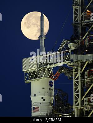 Una luna piena è dietro il razzo Space Launch System (SLS) della NASA, che si trova sul complesso 39B in preparazione ai test al Kennedy Space Center, Florida, mercoledì 15 giugno 2022. La NASA celebra anche il 60th° anniversario del Kennedy Space Center. Foto di Joe Marino/UPI Credit: UPI/Alamy Live News Foto Stock