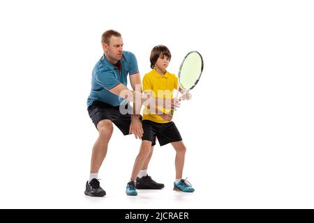 Formazione. Professionista giocatore di tennis, allenatore insegna teen a giocare a tennis isolato su sfondo bianco studio. Concetto di sport, realizzazioni, hobby Foto Stock