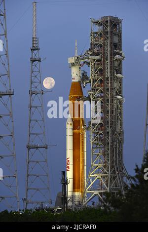 Una luna piena è dietro il razzo Space Launch System (SLS) della NASA, che si trova sul complesso 39B in preparazione ai test al Kennedy Space Center, Florida, mercoledì 15 giugno 2022. La NASA celebra anche il 60th° anniversario del Kennedy Space Center. Foto di Joe Marino/UPI Credit: UPI/Alamy Live News Foto Stock