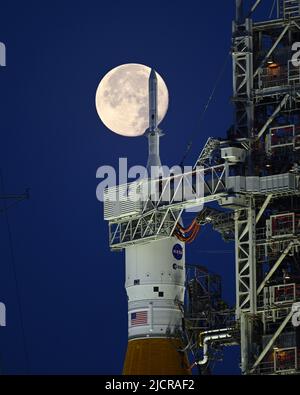 Una luna piena è dietro il razzo Space Launch System (SLS) della NASA, che si trova sul complesso 39B in preparazione ai test al Kennedy Space Center, Florida, mercoledì 15 giugno 2022. La NASA celebra anche il 60th° anniversario del Kennedy Space Center. Foto di Joe Marino/UPI Credit: UPI/Alamy Live News Foto Stock