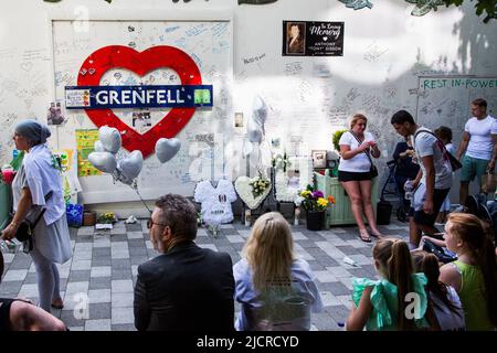 Londra, Regno Unito. 14th giugno 2022. Le persone si levano in piedi e pagano i loro rispetti di fronte ad un muro che circonda la Grenfell Tower nella parte ovest di Londra. I sopravvissuti al fuoco della Grenfell Tower e i parenti in lutto iniziarono un giorno di commemorazione a cinque anni dal disastro e chiesero alle autorità di consegnare finalmente giustizia. Credit: SOPA Images Limited/Alamy Live News Foto Stock