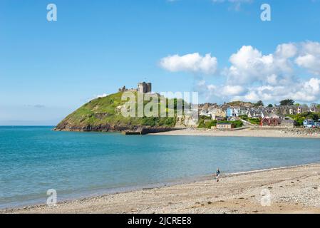 Una giornata di sole sulla spiaggia di Criccieth con la città e il castello sulla costa del Galles del Nord, Regno Unito. Foto Stock