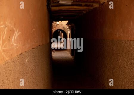 Ombre in un vecchio sottopasso su una strada vuota nella storica città murata nella Medina di Marrakesh, Marocco. Foto Stock