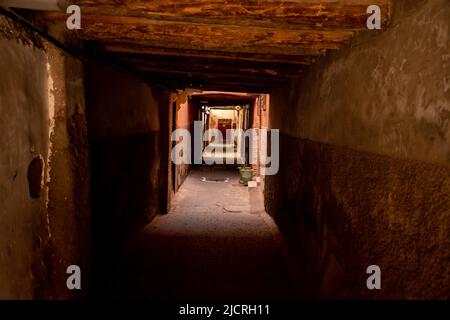 Ombre in un vecchio sottopasso su una strada vuota nella storica città murata nella Medina di Marrakesh, Marocco. Foto Stock