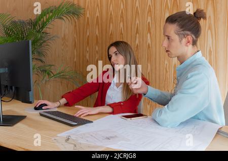 Progettisti di interni che pensano e progettano nuovi projet insieme nel calcolatore Foto Stock