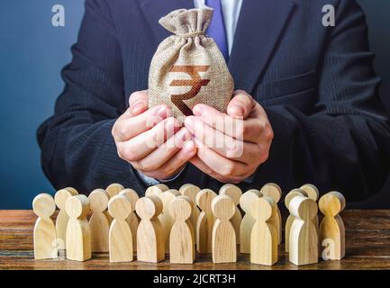 L'uomo d'affari tiene fuori un sacchetto indiano di soldi della rupia alla folla. Sostegno finanziario. Riscossione delle imposte. Pagamenti compensativi. Profitto azionario. Fornire denaro, Foto Stock