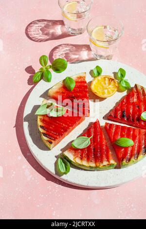 fette di anguria grigliate con limone e basilico. dessert estivo Foto Stock