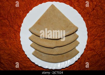 Pane pita morbido e gustoso, cucina arabica o turca. Pitta di grano tagliata a quattro pezzi e servita su piatto bianco Foto Stock