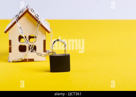 Arresto dell'alloggiamento. Casa del castello. Piccola casa giocattolo e una catena con un lucchetto. Foto Stock