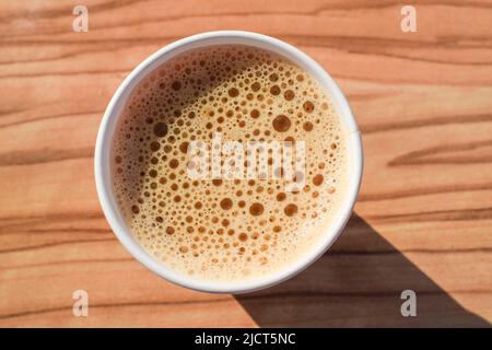 Vista dall'alto della macchina appena preparata caffè istantaneo. Vista dall'alto del caffè su un tavolo di legno durante la prima colazione. Foto Stock