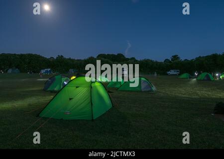 Un gruppo di tende (durante un viaggio del duca di Edimburgo) in un campo sotto una luna piena vicina a Dorset, Regno Unito. Foto Stock