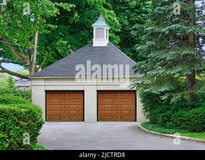 Garage residenziale indipendente circondato da alberi Foto Stock