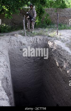 U.S. Marine Corps Sgt. Steven guek, 2nd leader della squadra, con 1st battaglione, 8th Marine Division, Regimental Combat Team 6, si trova accanto a una mano scavata noi Foto Stock