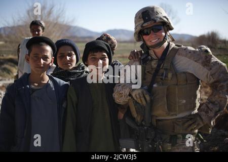 Una Marina statunitense con la Female Engagement Team (FET), 1st Battaglione, 8th Marine Regiment (1/8), Regimental Combat Team 6, pone per una foto con afghan chi Foto Stock