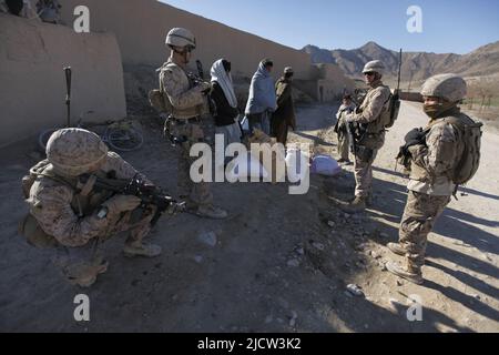 U.S. Marines with Weapons Company, 1st Battaglione, 8th Marine Regiment (1/8), Regimental Combat Team 6, stop and question afghan men about illegale fert Foto Stock