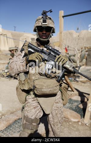 U.S. Navy Hospital Corpsman with Weapons Company, 1st Battaglione, 8th Regiment Marino (1/8), Regimental Combat Team 6, pone per una foto dopo pattrolli Foto Stock