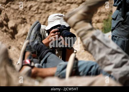 Ben Foley, uomo della macchina fotografica con al Jazeera English News Channel filma la polizia locale afghana in uniforme durante una sessione di addestramento fisico accanto a U.S. Marin Foto Stock