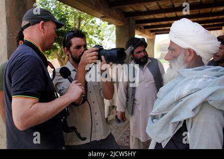 Bernard Smith, a sinistra, giornalista, e ben Foley, al centro, Cameraman, con al Jazeera English News Channel intervista un insegnante locale della scuola nazionale afghana Foto Stock