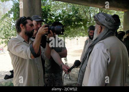 Ben Foley, a sinistra, cameraman, e Bernard Smith, al centro, reporter, con al Jazeera English News Channel intervista un insegnante locale della scuola nazionale afghana Foto Stock