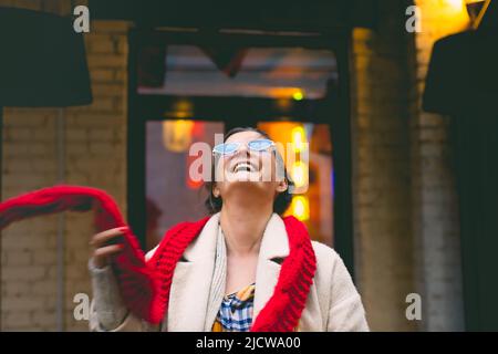 Una donna attraente e ridente cammina attraverso un quartiere giapponese della città. Vista frontale. Foto Stock