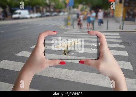 3d proiezione di dinosauri in strada con smart phone e tecnologia di realtà aumentata Foto Stock