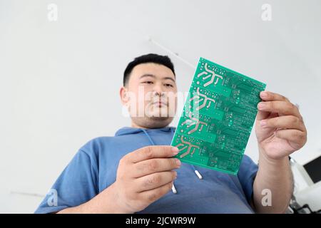 BINZHOU, CINA - 16 GIUGNO 2022 - Un tecnico esamina una scheda a circuito integrato sviluppata dalla società nella città di Xingfu della contea di Boxing, Binzhou C. Foto Stock