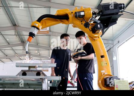 BINZHOU, CINA - 16 GIUGNO 2022 - due tecnici effettuano il debug di un prodotto di ordine di un robot industriale di nuova concezione presso la Black Dot Electronics Technology Foto Stock
