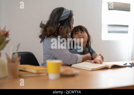 Buona nonna vecchia abbracciando la bambina del nonno piccolo, sorridendo la madre matura o la nonna grande ridendo abbracciando la nonna adottata del capretto Foto Stock