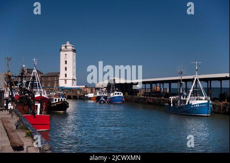 Barche da pesca e faro a luci basse a North Shields Fish Quay Foto Stock