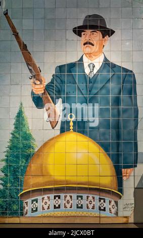 Un grande murale incorniciato da Iraq in mostra presso l'Imperial War Museum di Londra (IWM) che mostra l'ex dittatore Saddam Hussein. Foto Stock