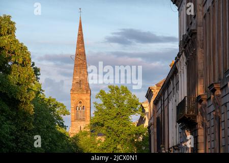 Guglia dell'ex chiesa parrocchiale di KelvInside, ora centro culturale Oran Mor. Sulla destra, le proprietà terrazza nel West End della città. Fotografato a. Foto Stock