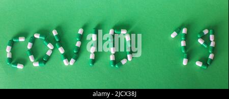 Iscrizione Covid 19 da lettere fatte di pillole su sfondo verde. Corona virus concept. Banner